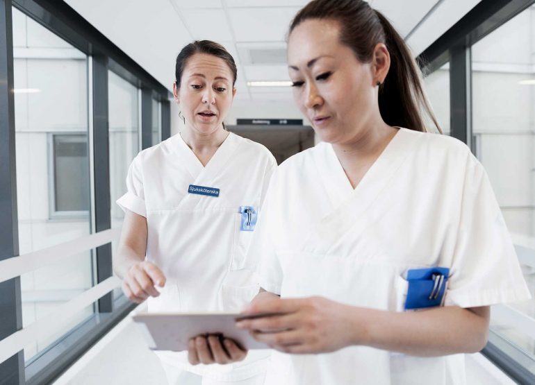 Doctor and nurse with mobile EHR electronic health recond on ipad